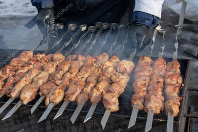 Charcoal grill with skewers sizzling